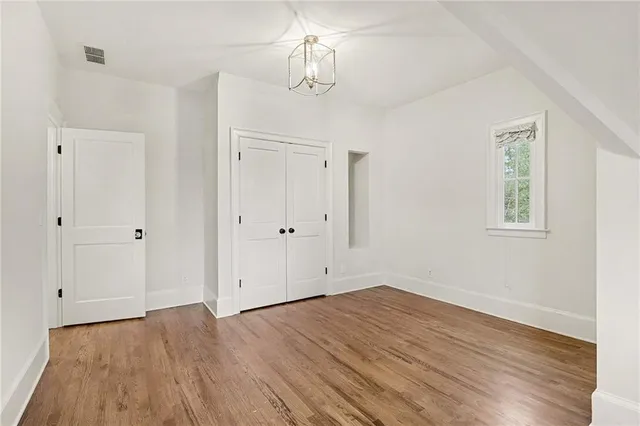 a view of empty room with wooden floor