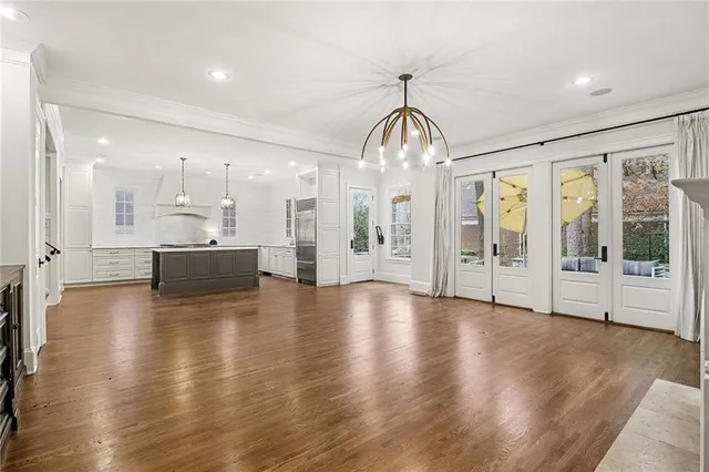 a view of an empty room with wooden floor and a fireplace