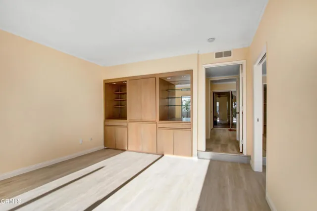 a view of a bedroom with wooden floor and bathroom