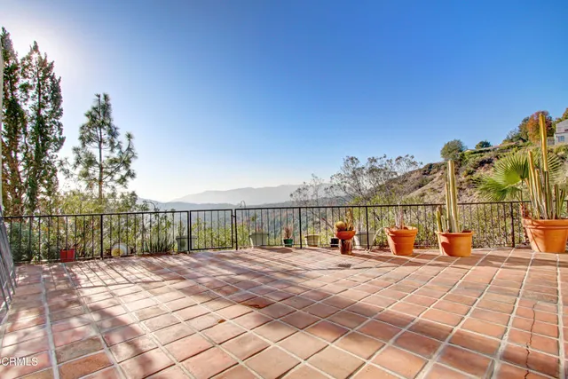 a view of swimming pool with lawn chairs and iron fence