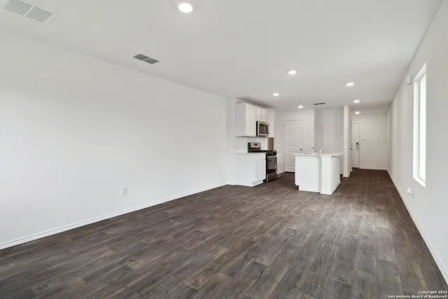 a view of empty room with wooden floor
