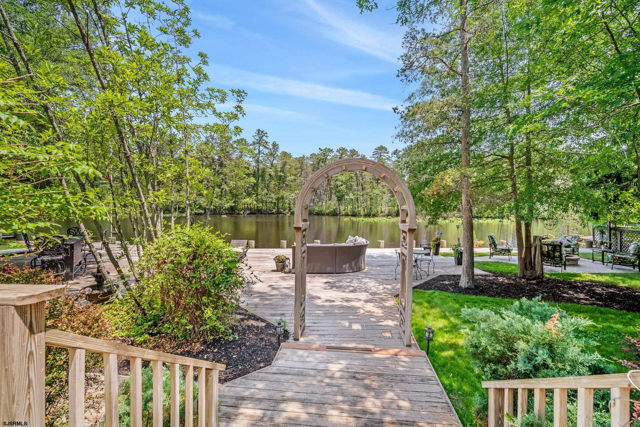 4646 Riverside Drive Sweetwater, NJ 08037 - Photo 32 of 55 a view of a patio with table and chairs potted plants and large tree