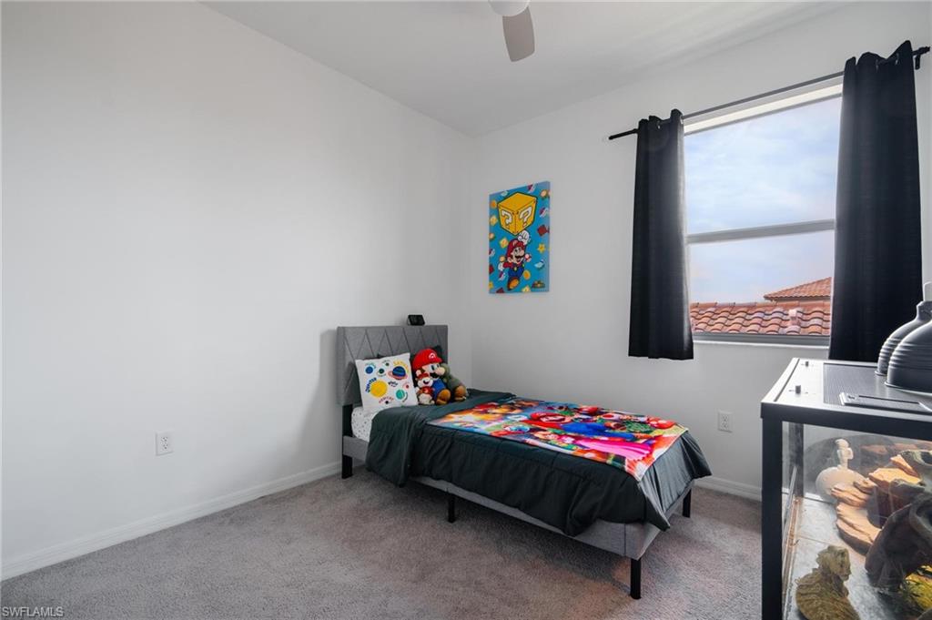 5519 Useppa Drive Ave Maria, FL 34142 - Photo 20 of 32 a bedroom with a bed a couch and a window