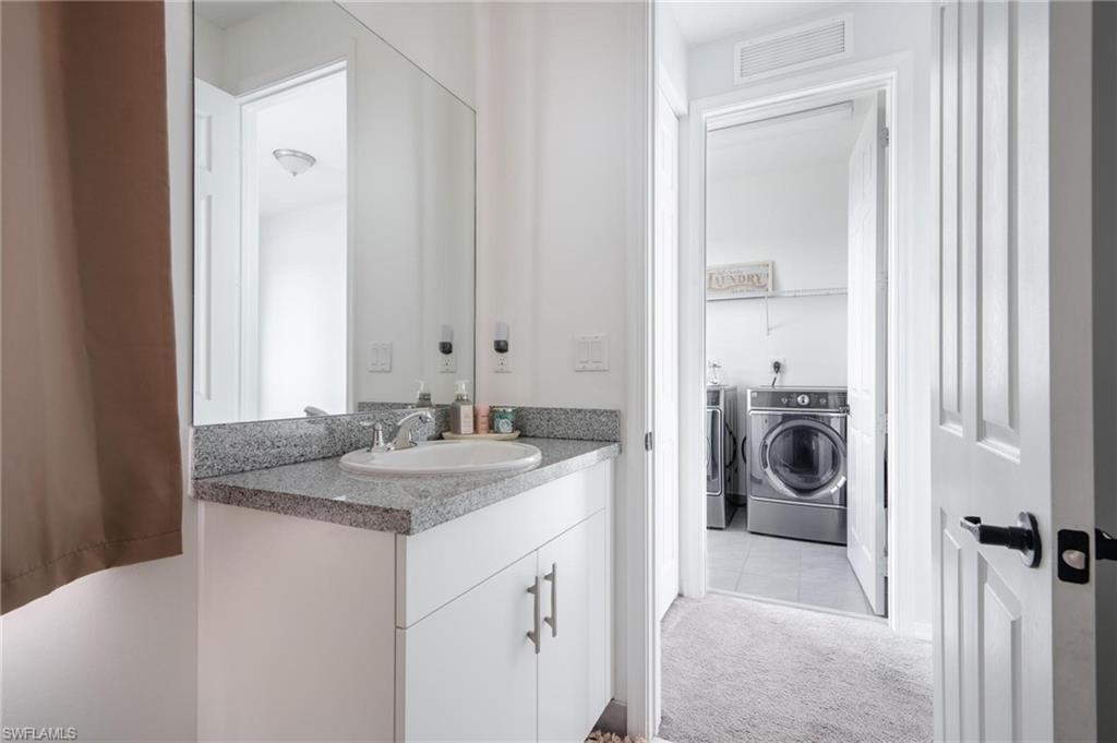 5519 Useppa Drive Ave Maria, FL 34142 - Photo 23 of 32 a bathroom with a sink and a washing machine with a mirror