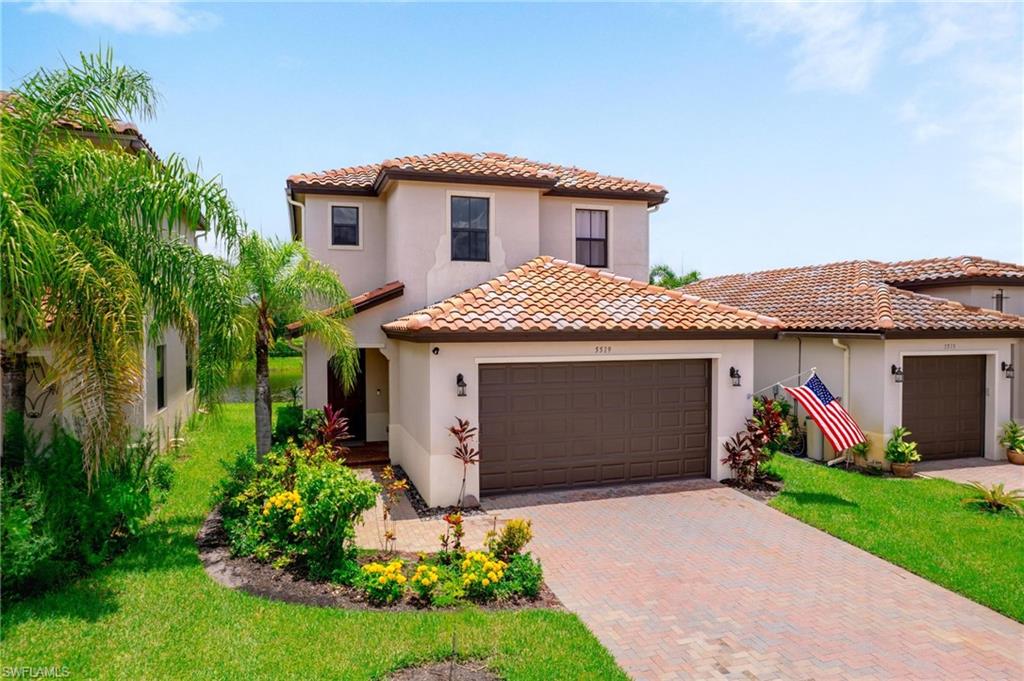 5519 Useppa Drive Ave Maria, FL 34142 - Photo 25 of 32 a front view of a house with a garden and plants