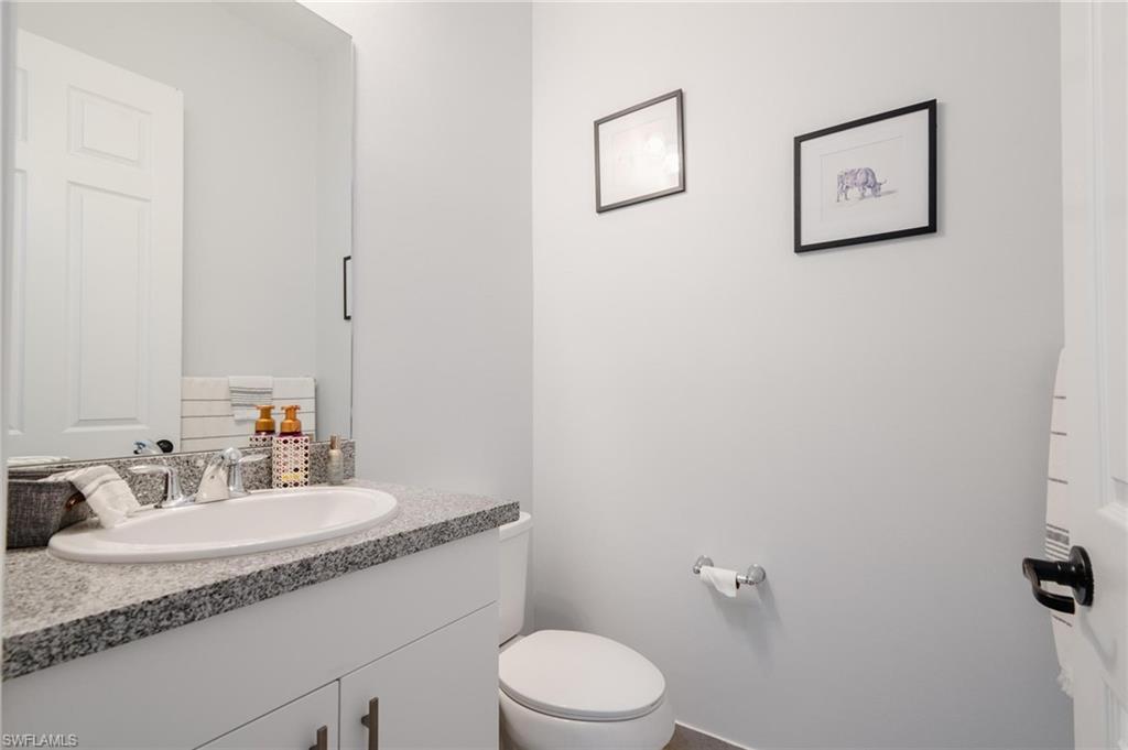 5519 Useppa Drive Ave Maria, FL 34142 - Photo 7 of 32 a bathroom with a granite countertop sink mirror vanity and toilet