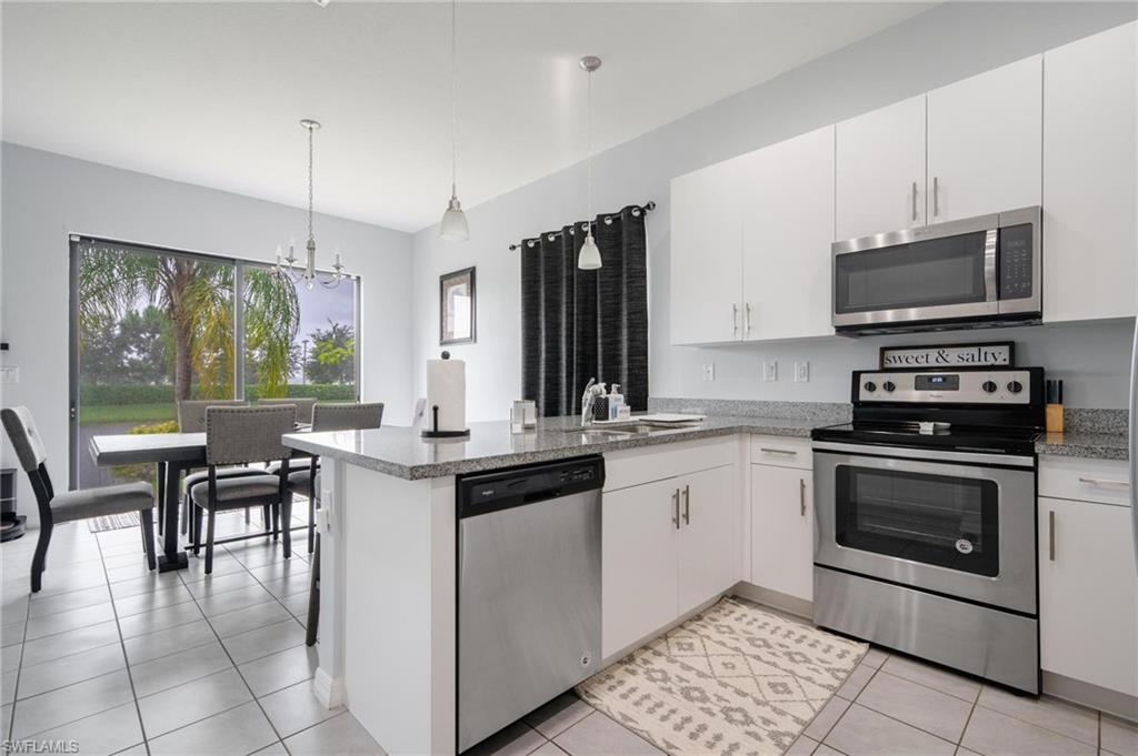 5519 Useppa Drive Ave Maria, FL 34142 - Photo 8 of 32 a kitchen with a stove a sink and a microwave