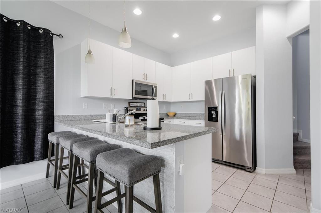 5519 Useppa Drive Ave Maria, FL 34142 - Photo 9 of 32 a kitchen with kitchen island a counter top space cabinets and stainless steel appliances