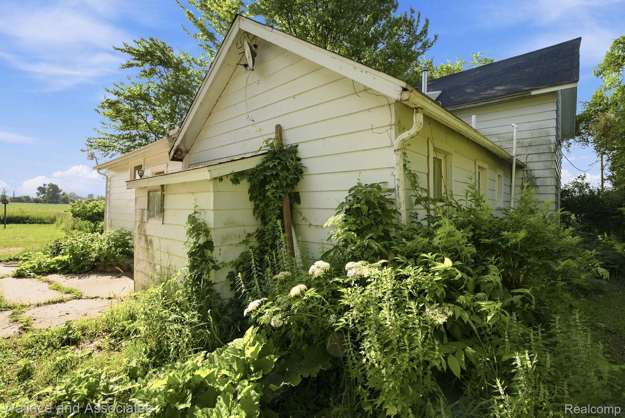 5949 Roach Road Croswell, MI 48422 - Photo 42 of 48 White siding exterior with a dark shingle roof and white gutters