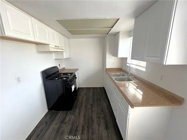 a kitchen with stainless steel appliances granite countertop a refrigerator a sink and wooden cabinets