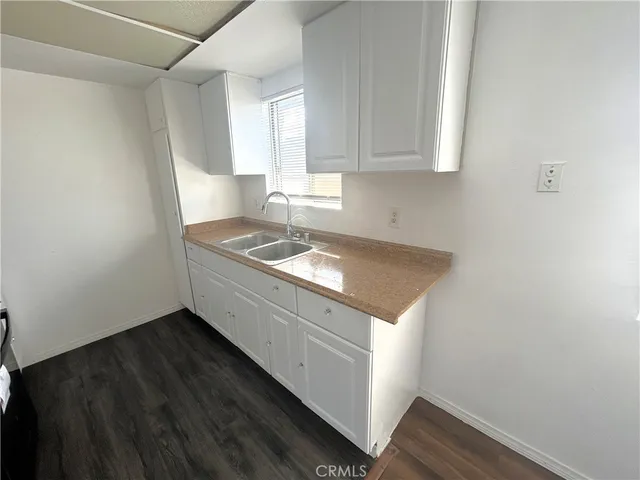 a utility room with granite countertop white cabinets and a granite counter tops