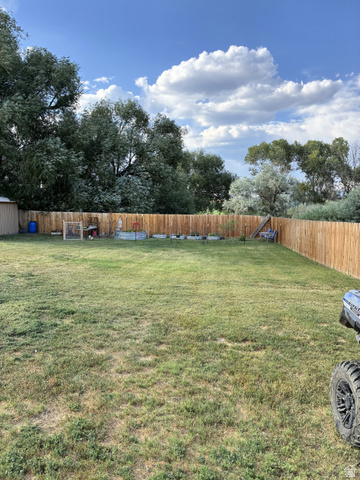 547 East 2000th Street North Vernal, UT 84078 - Photo 47 of 50 Expansive backyard with a full wood privacy fence, mature trees, and a wooden storage shed