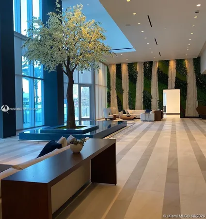 a view of swimming pool that has lawn chairs potted plants and palm trees