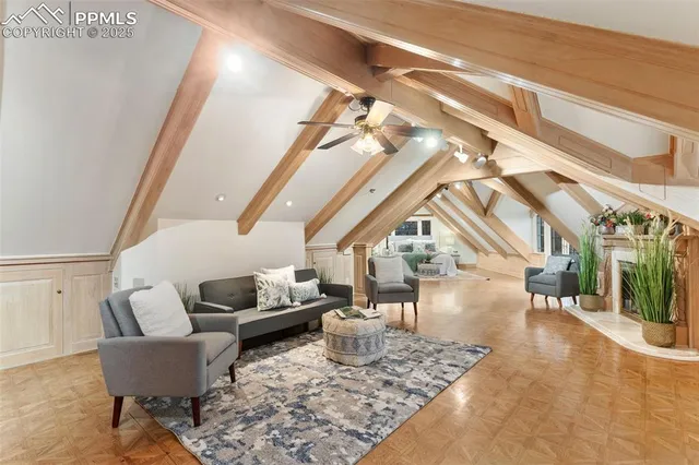 a living room with couches and a dining table with wooden floor