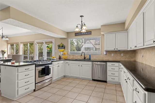 a kitchen with white cabinets stainless steel appliances and sink