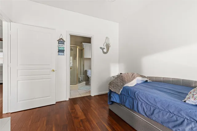 a room with a bed and wooden floor