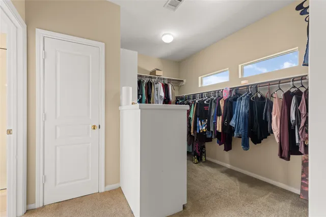 a view of walk in closet with clothes and shoes