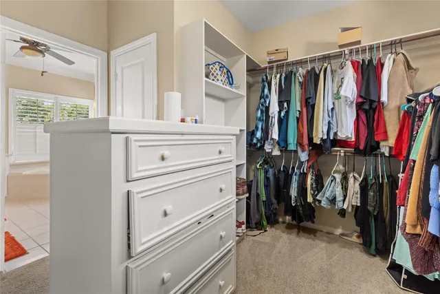 a view of walk in closet with clothes and shoes