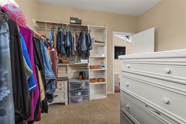 a view of walk in closet with clothes and shoes