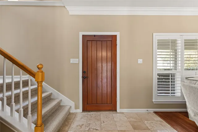 a view of front door with wooden floor and stairs