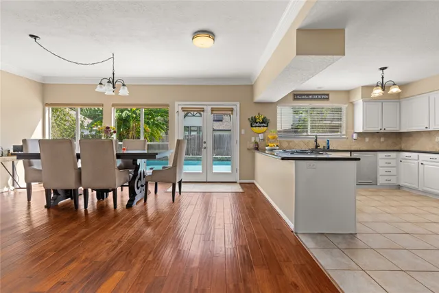 a kitchen with stainless steel appliances granite countertop hardwood floor sink stove dining table and chairs