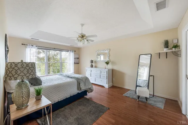 a bedroom with a bed a chandelier and a window