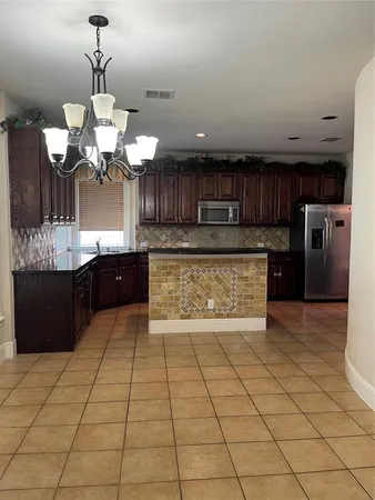 a large kitchen with stainless steel appliances granite countertop a stove a sink and a microwave