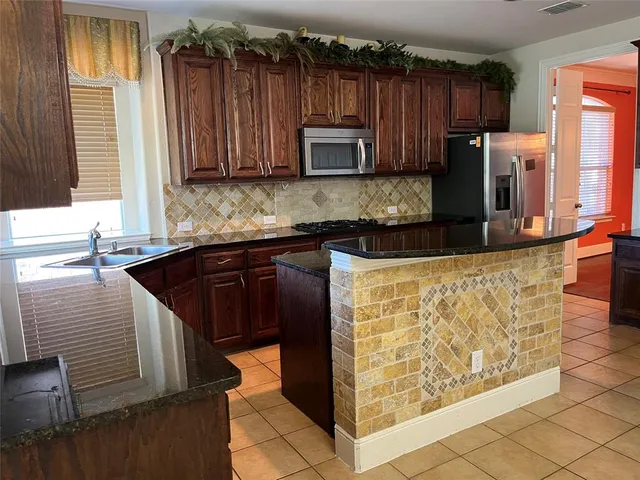 a kitchen with stainless steel appliances granite countertop a sink stove and microwave