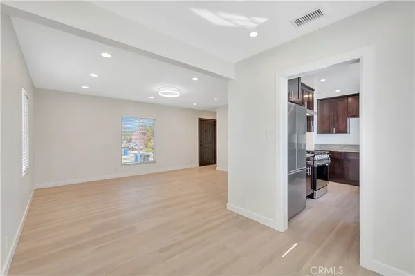 a view of a hallway with wooden floor and a living room
