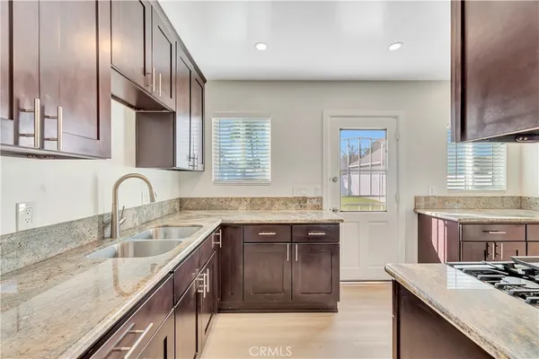 a kitchen with a sink stove top oven and cabinets