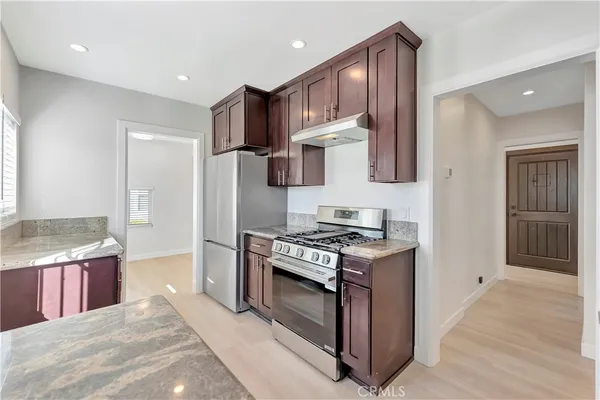 a kitchen with stainless steel appliances granite countertop a stove a refrigerator and a refrigerator