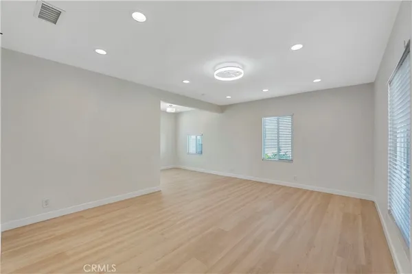 an empty room with wooden floor and window