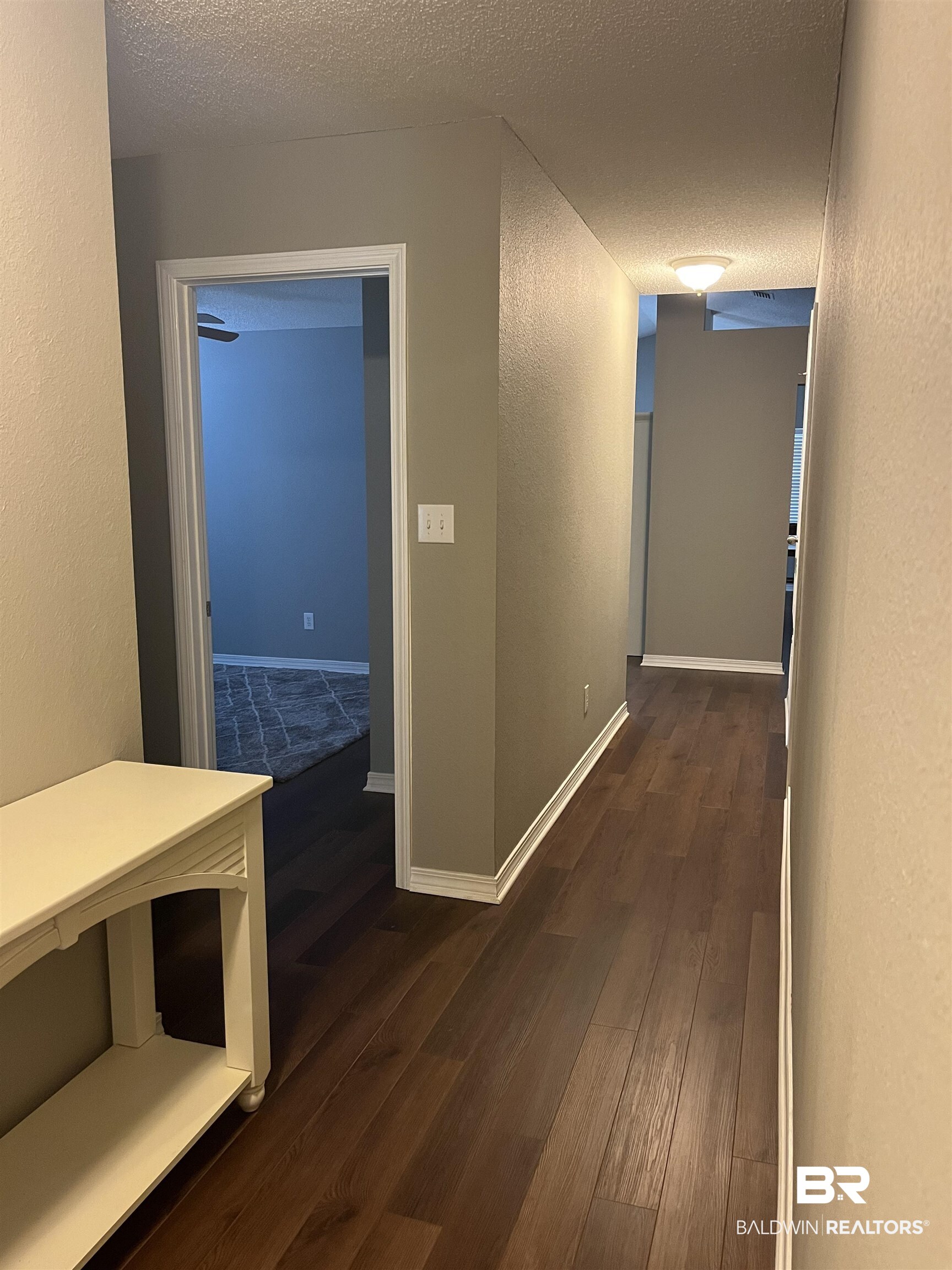 309 Cluster Street Foley, AL 36535 - Photo 21 of 38 Hallway featuring wood-finish flooring, neutral wall tones, white baseboards, and a flush-mount ceiling light fixture