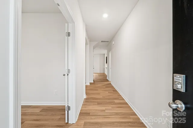 a view of a hallway with wooden floor and staircase