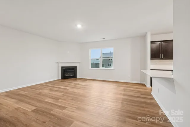 a view of an empty room with a window and fireplace