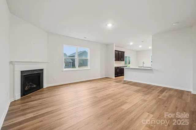 a view of empty room with wooden floor and fireplace
