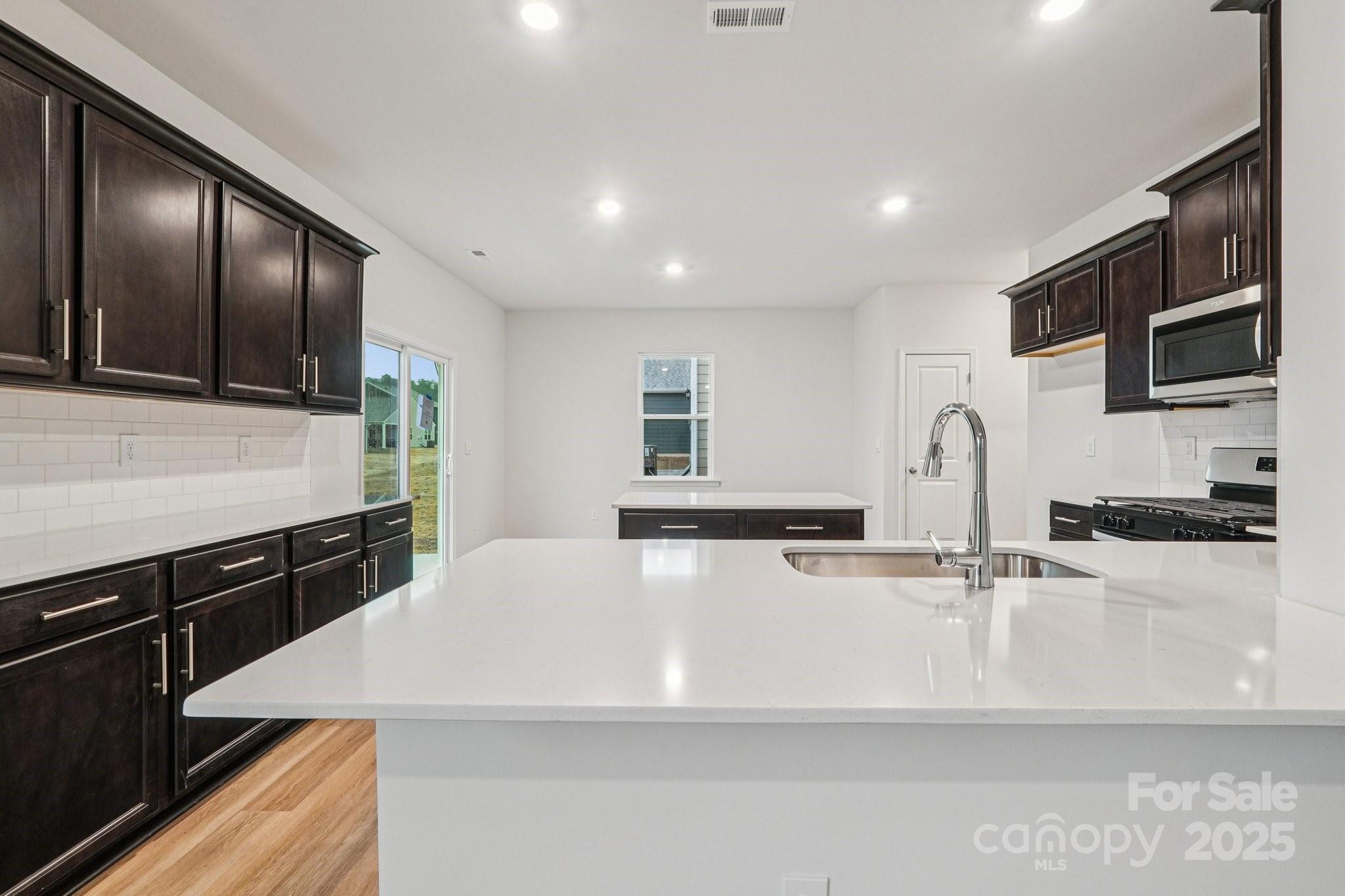 7636 Bainbridge Road Sherrills Ford, NC 28673 - Photo 7 of 31 a large kitchen with stainless steel appliances a large counter top a stove and a sink