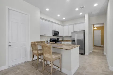 a kitchen with stainless steel appliances granite countertop a refrigerator and a stove top oven