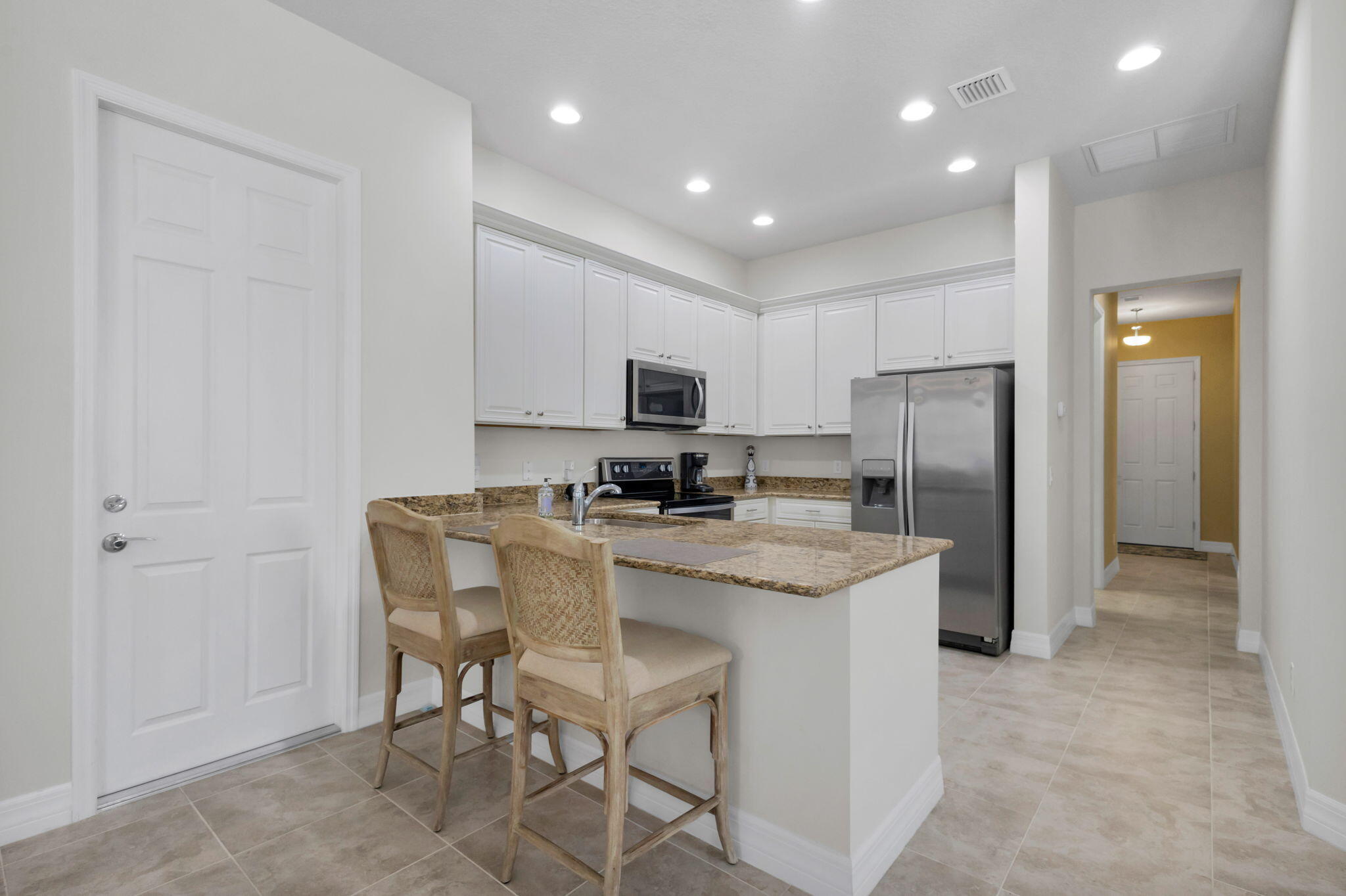 1122 South Prescott Drive Jupiter, FL 33458 - Photo 17 of 43 a kitchen with stainless steel appliances granite countertop a refrigerator and a stove top oven