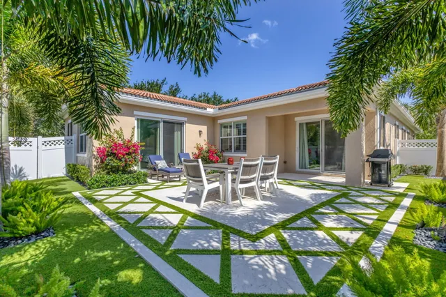 a view of a house with backyard and sitting area