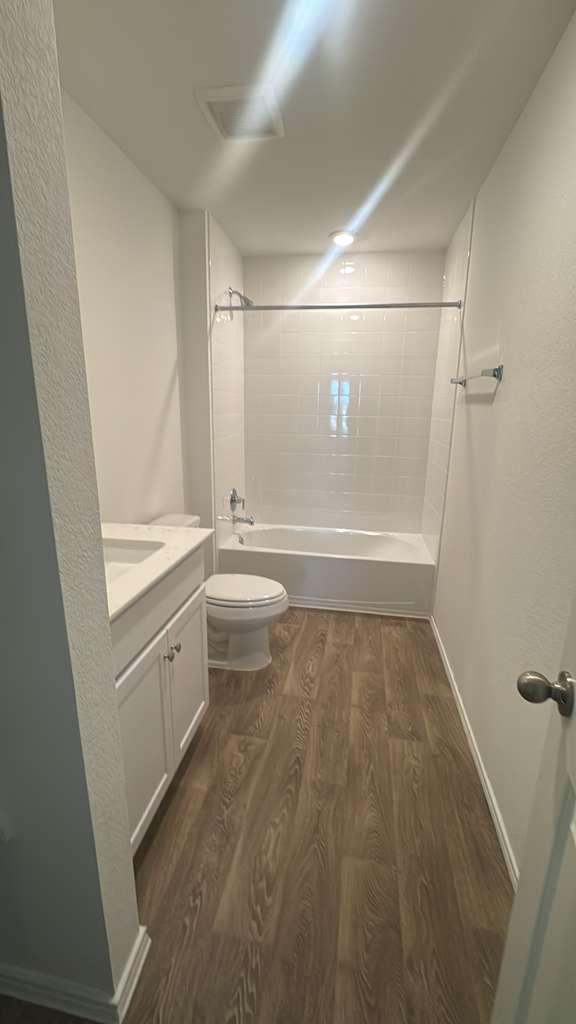 174 Balmorhea Street Kyle, TX 78640 - Photo 17 of 29 A well-appointed bathroom offers a clean aesthetic with a full bath and wood-look flooring.