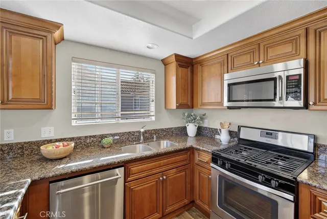 a kitchen with granite countertop a stove sink and microwave