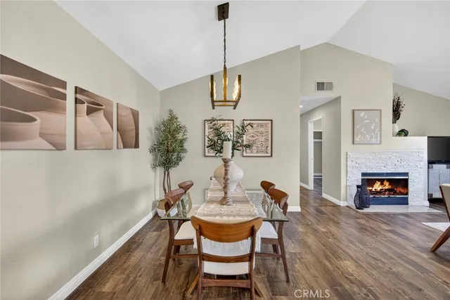 a dining room with furniture a fireplace and wooden floor