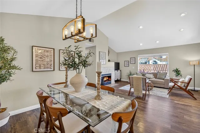 a dining room with wooden floor a chandelier a wooden table and chairs