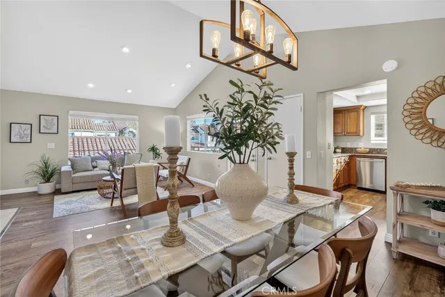 a living room with furniture a chandelier and wooden floor