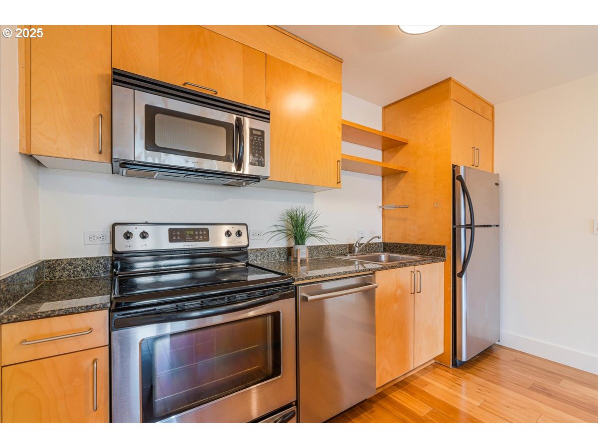 255 Southwest Harrison Street, Unit 11A Portland, OR 97201 - Photo 13 of 32 a kitchen with stainless steel appliances granite countertop a stove and a microwave