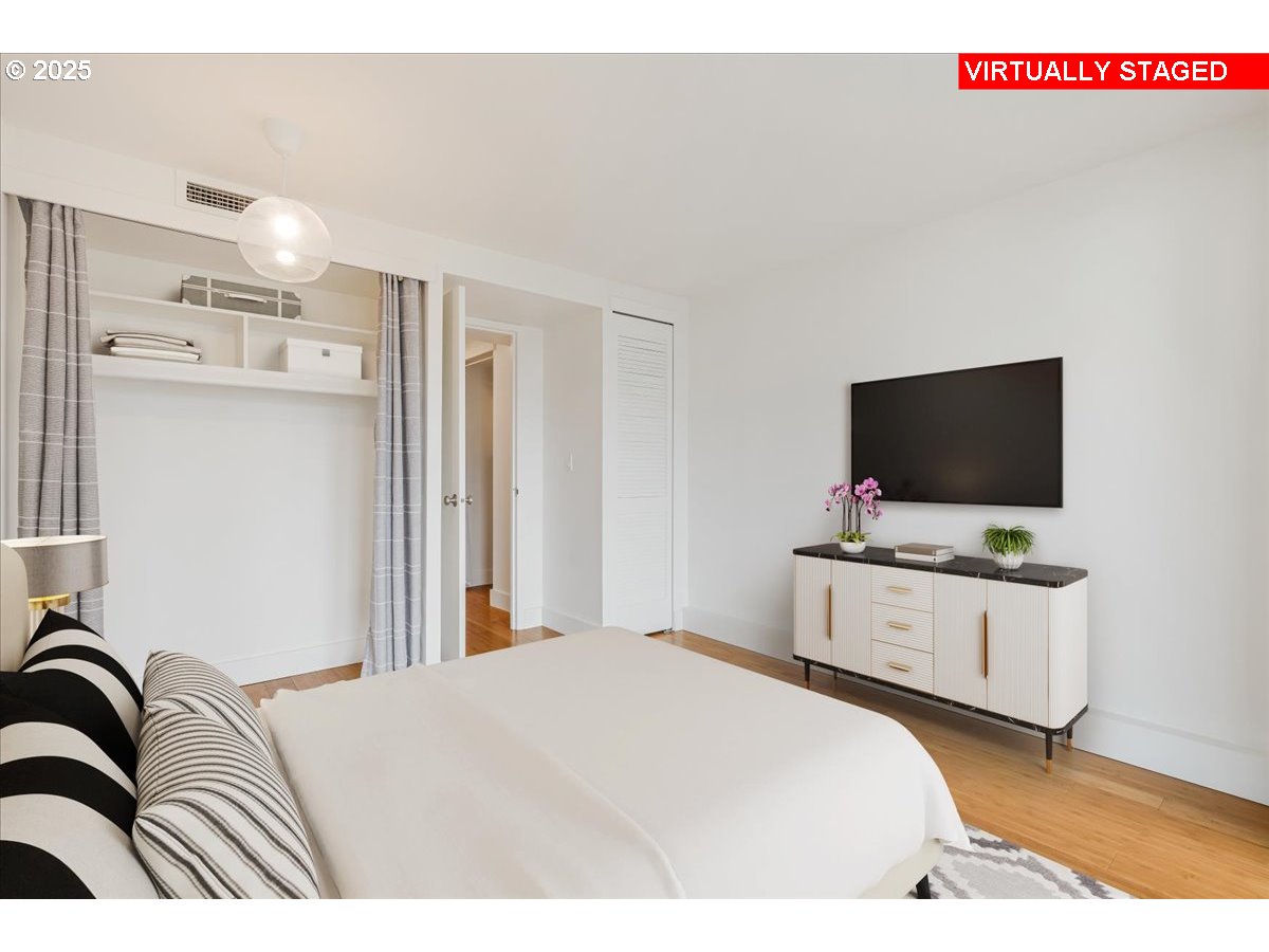 255 Southwest Harrison Street, Unit 11A Portland, OR 97201 - Photo 16 of 32 a bedroom with a bed and a flat screen tv