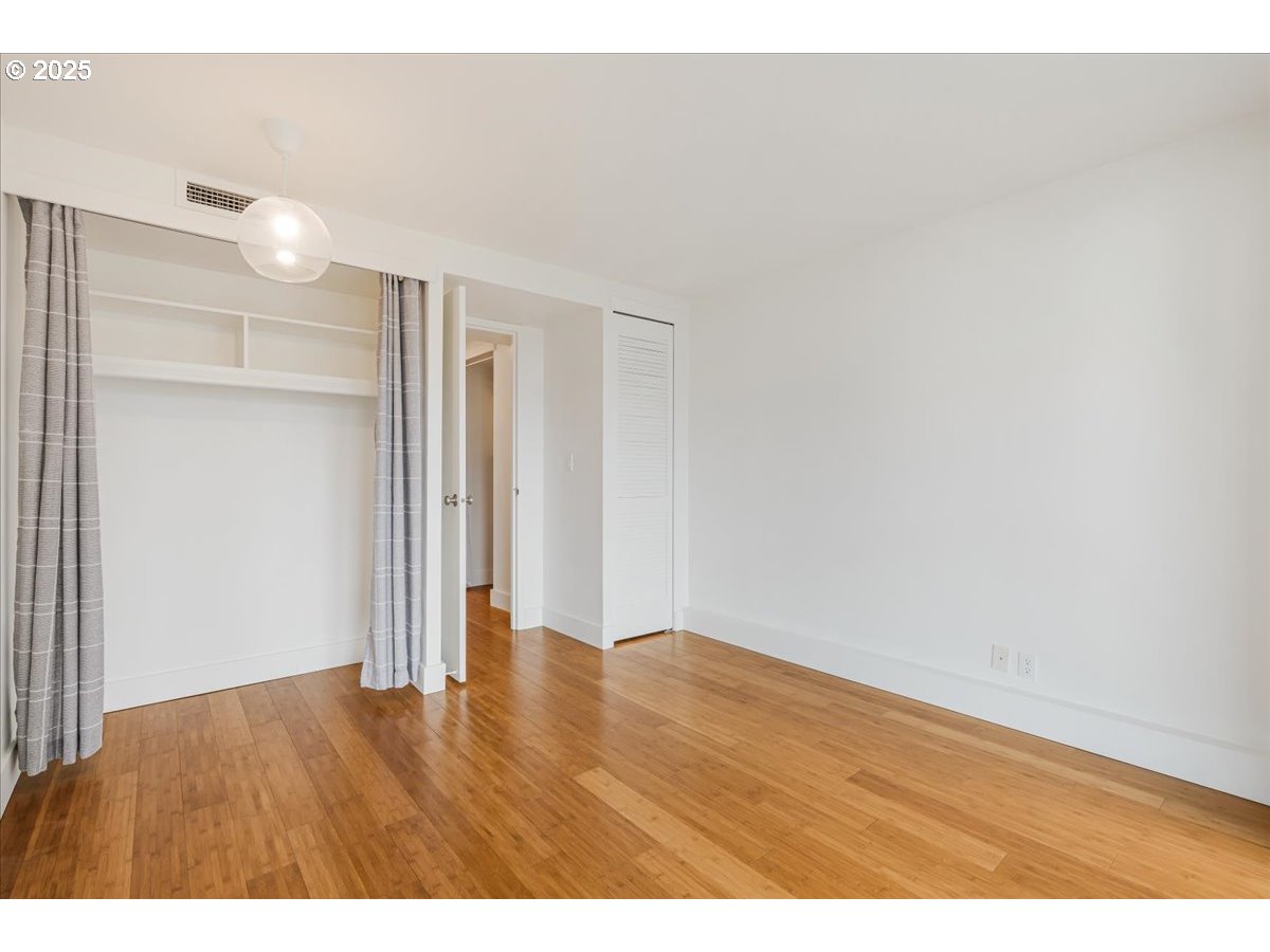 255 Southwest Harrison Street, Unit 11A Portland, OR 97201 - Photo 17 of 32 a view of an empty room with wooden floor