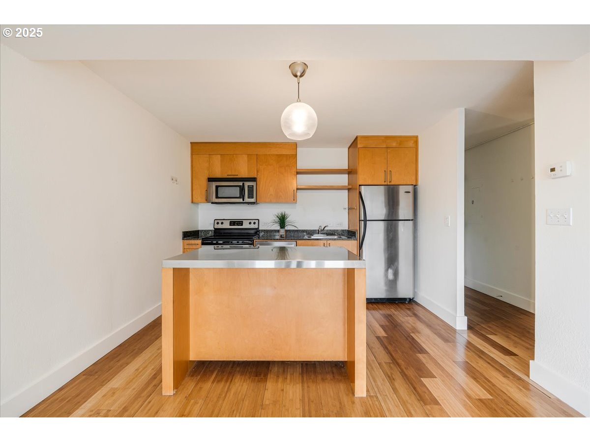 255 Southwest Harrison Street, Unit 11A Portland, OR 97201 - Photo 28 of 32 a kitchen with stainless steel appliances granite countertop a stove a refrigerator and a microwave