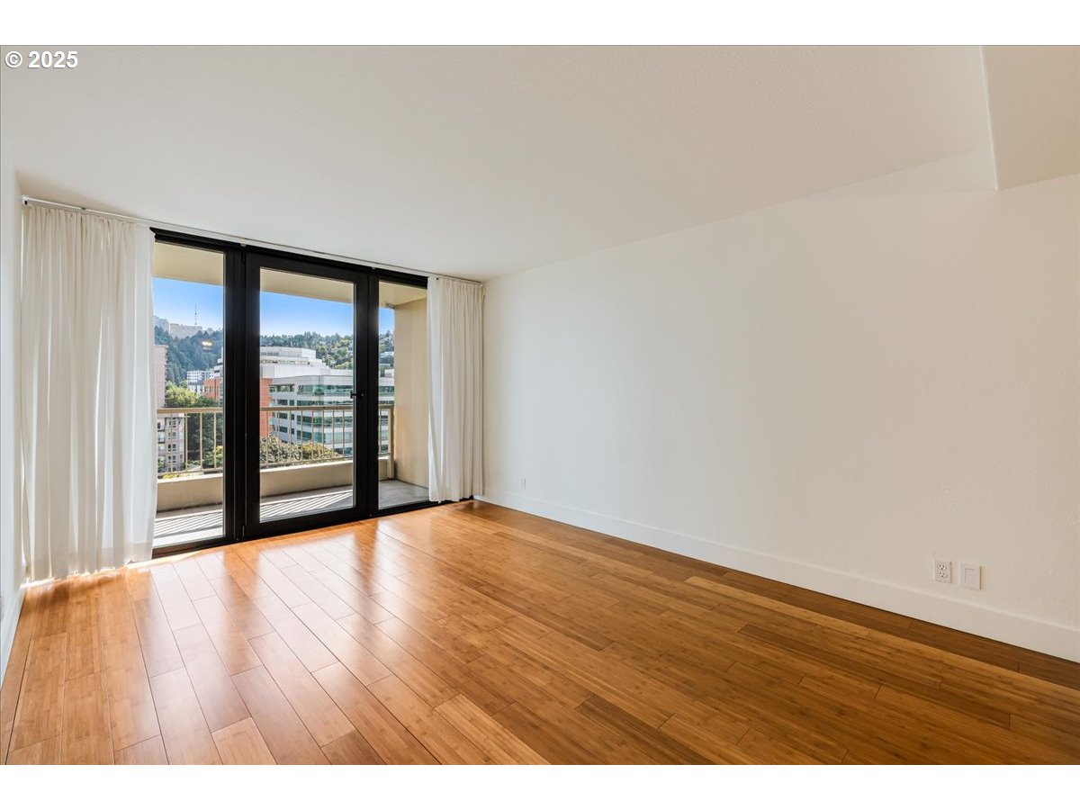 255 Southwest Harrison Street, Unit 11A Portland, OR 97201 - Photo 29 of 32 a view of an empty room with wooden floor and a window